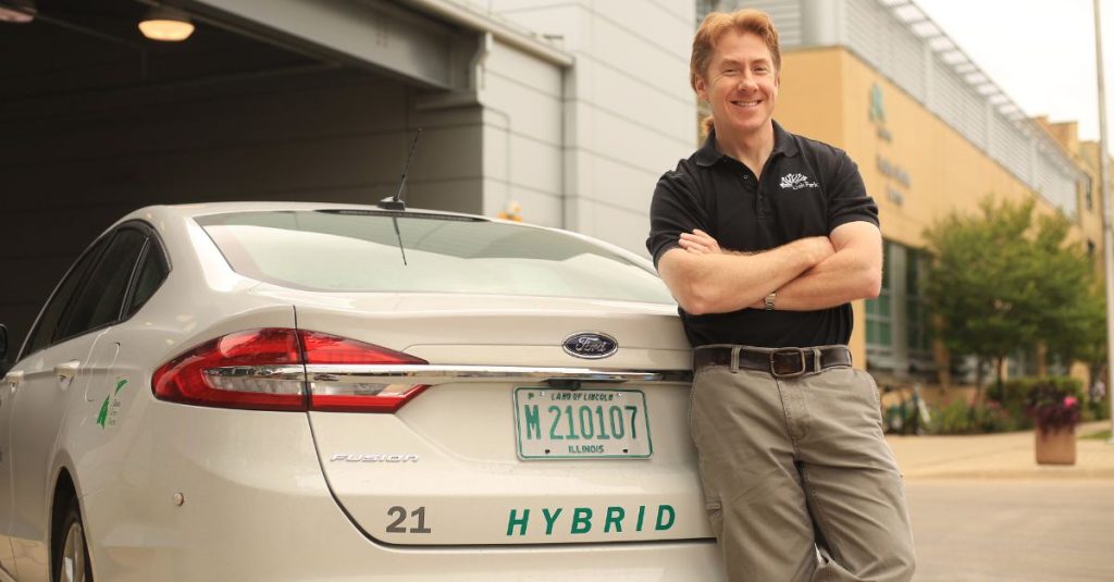 Superintendent of Fleet Services for the Village of Oak Park, Illinois, stands in front of hybrid vehicle